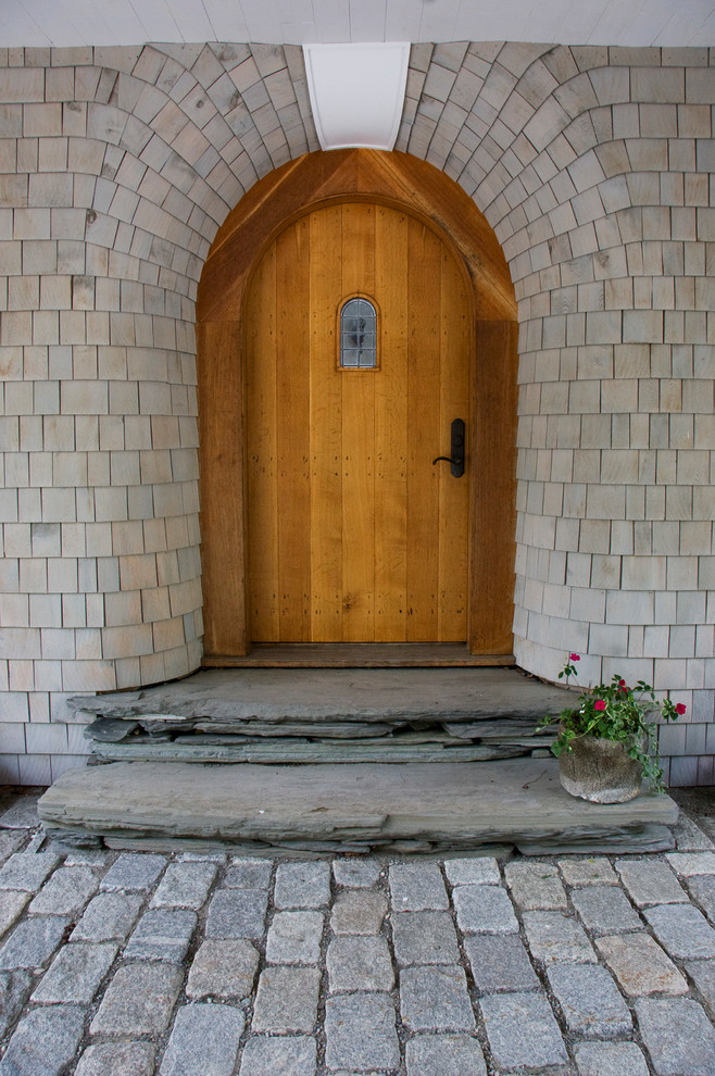 This is an example of a bohemian front door in Burlington with white walls, a single front door, a medium wood front door and beige floors.