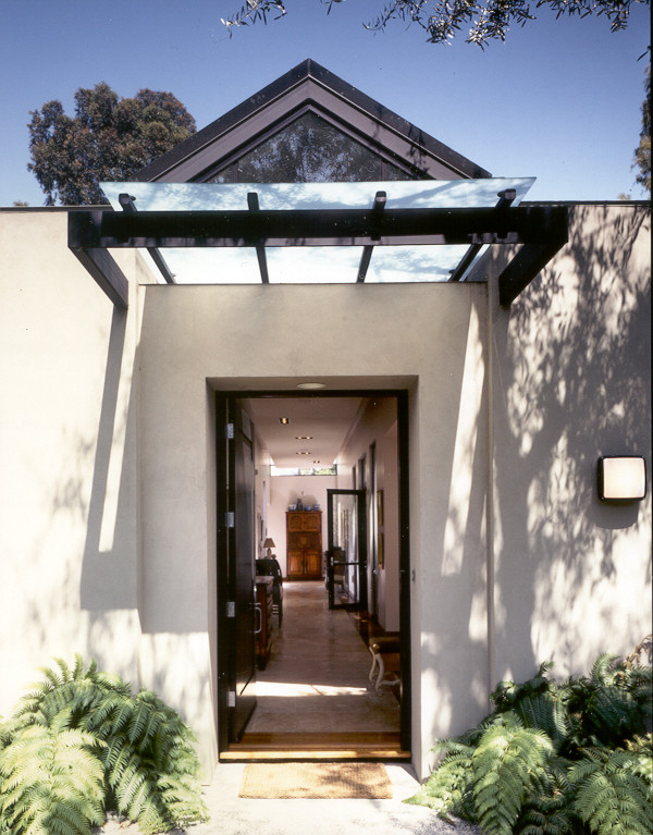 Ejemplo de hall contemporáneo de tamaño medio con paredes beige, suelo de piedra caliza, puerta simple y puerta negra