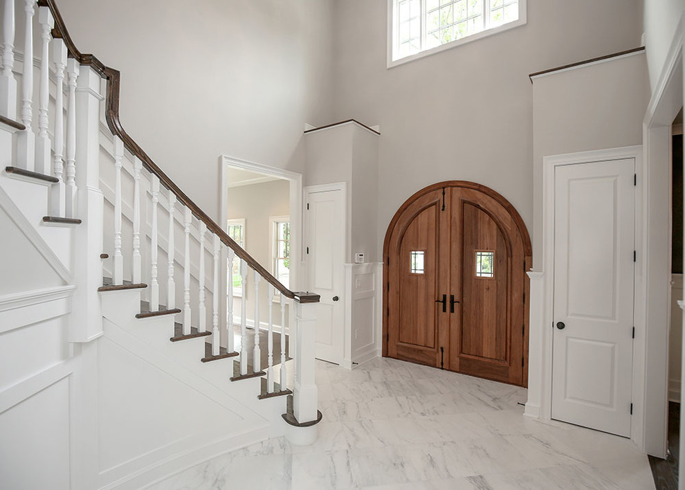 Imagen de distribuidor clásico renovado grande con paredes grises, suelo de mármol, puerta doble y puerta de madera clara