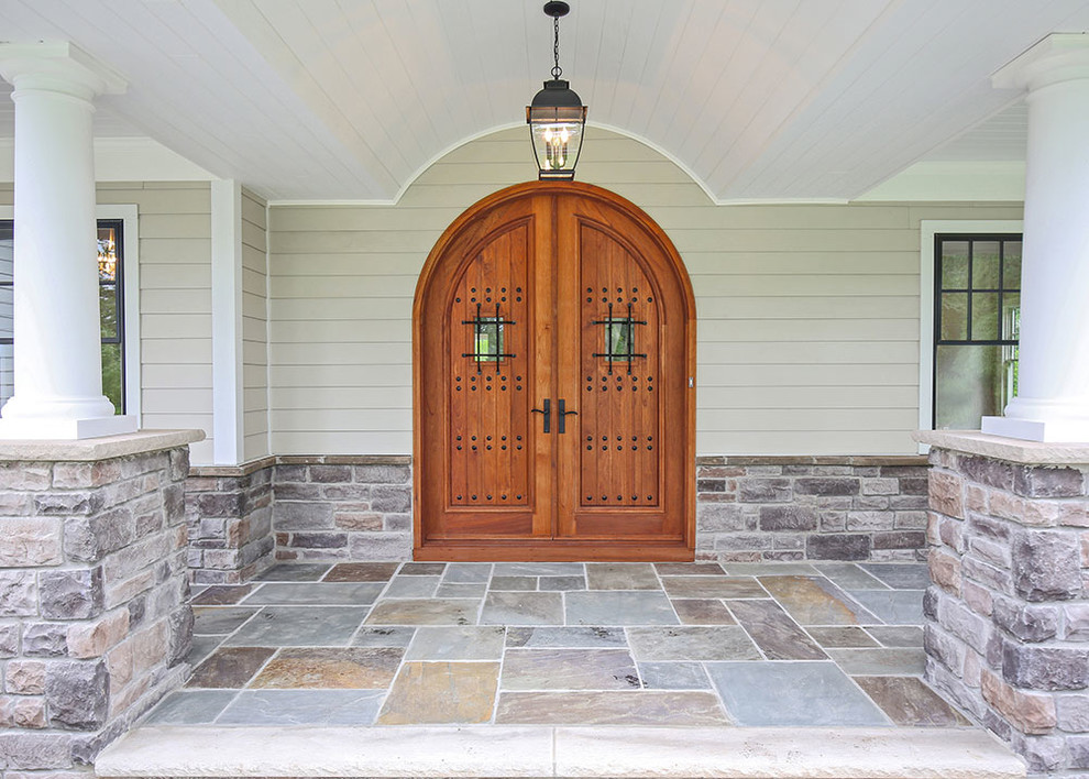 Modelo de puerta principal clásica renovada de tamaño medio con paredes beige, suelo de pizarra, puerta doble y puerta de madera en tonos medios
