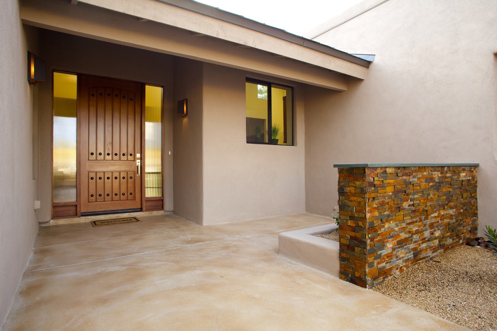Klassische Haustür mit beiger Wandfarbe, Betonboden, Einzeltür und hellbrauner Holzhaustür in Phoenix