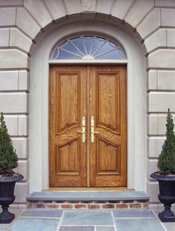 Diseño de entrada clásica con paredes beige, puerta de madera clara y puerta doble