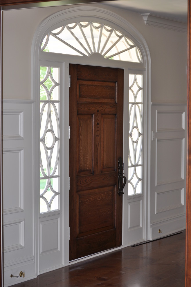 Réalisation d'une entrée tradition avec un mur beige, une porte en bois clair et une porte simple.