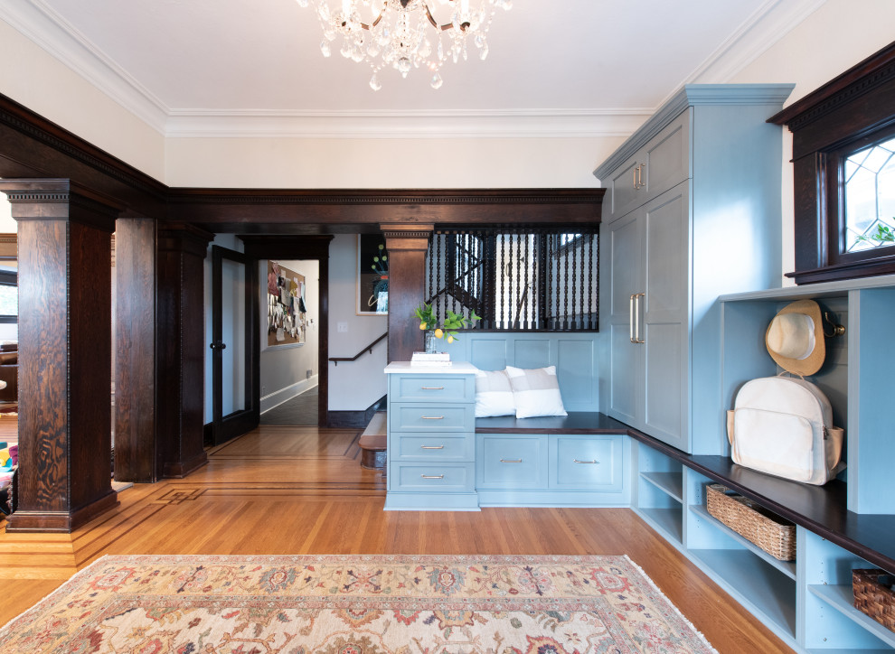 Kleines Klassisches Foyer mit weißer Wandfarbe, hellem Holzboden, Einzeltür, brauner Haustür und braunem Boden in Seattle