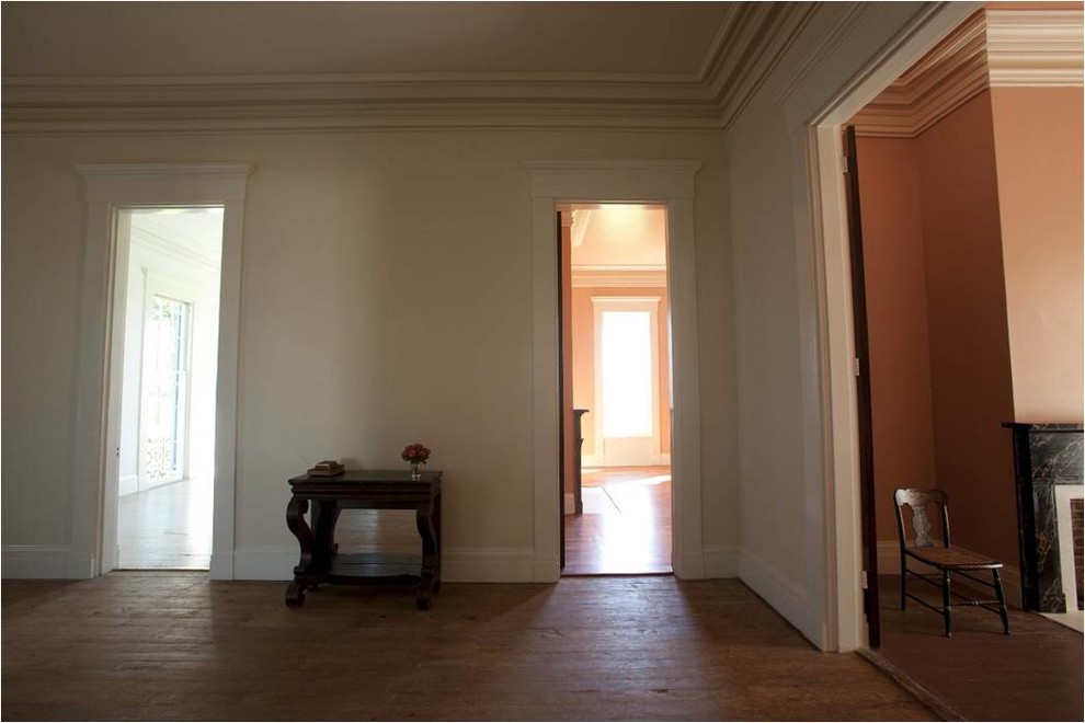 Geräumiges Klassisches Foyer mit gelber Wandfarbe, braunem Holzboden, Einzeltür und brauner Haustür in Little Rock