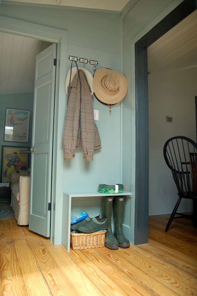 Photo of a farmhouse boot room in Austin with blue walls and yellow floors.