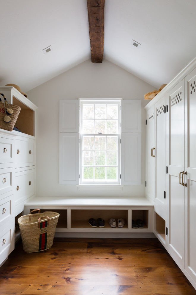Photo of a country boot room in Boston with white walls, medium hardwood flooring and brown floors.