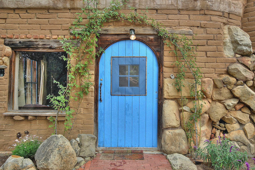 Modelo de entrada rústica con puerta simple y puerta azul