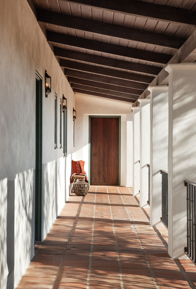 Пример оригинального дизайна: входная дверь среднего размера в средиземноморском стиле с белыми стенами, полом из керамической плитки, одностворчатой входной дверью и входной дверью из темного дерева
