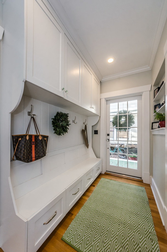 Klassischer Eingang mit Korridor, beiger Wandfarbe, braunem Holzboden, Einzeltür, weißer Haustür und braunem Boden in Tampa