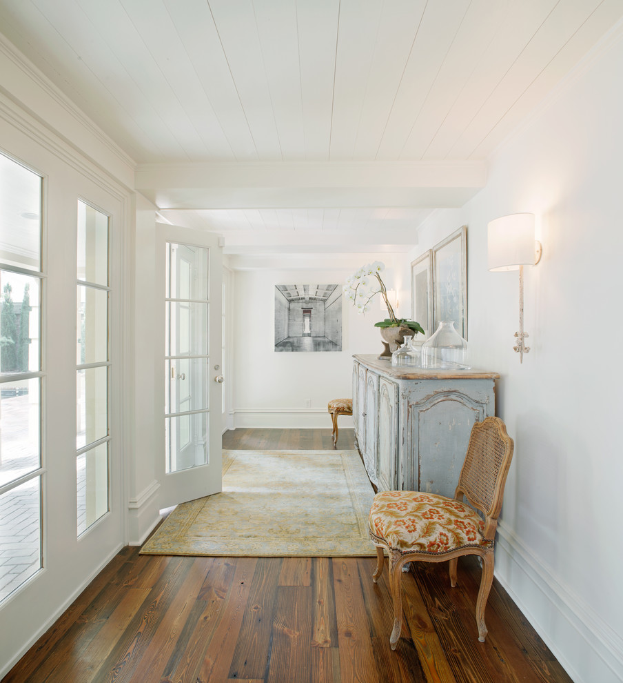 Inspiration pour une entrée traditionnelle avec un couloir, un mur blanc, un sol en bois brun et une porte en verre.