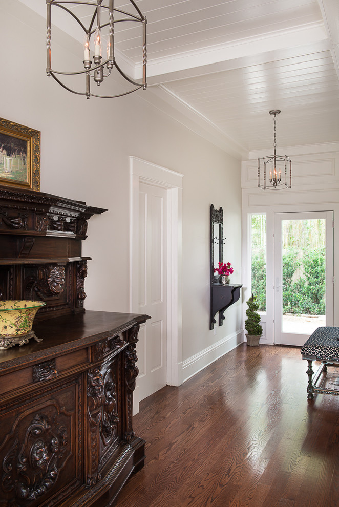 Idée de décoration pour une grande entrée tradition avec un couloir, un sol en bois brun, une porte simple et une porte blanche.