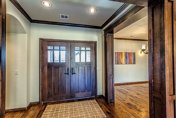 Idee per un ingresso stile americano di medie dimensioni con pareti verdi, pavimento in legno massello medio, una porta a due ante, una porta in legno scuro e pavimento marrone