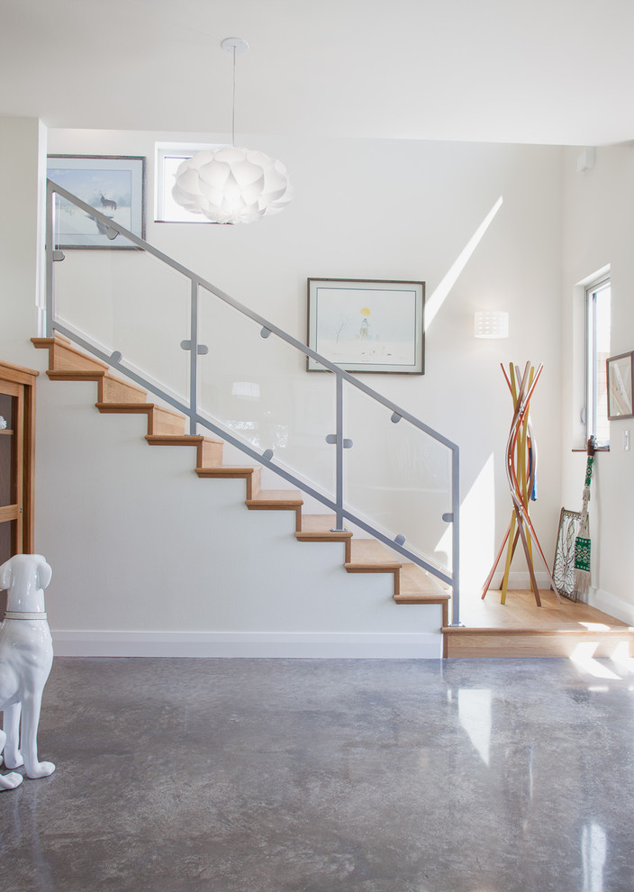 Inspiration pour une entrée design avec sol en béton ciré, un sol gris et un mur blanc.