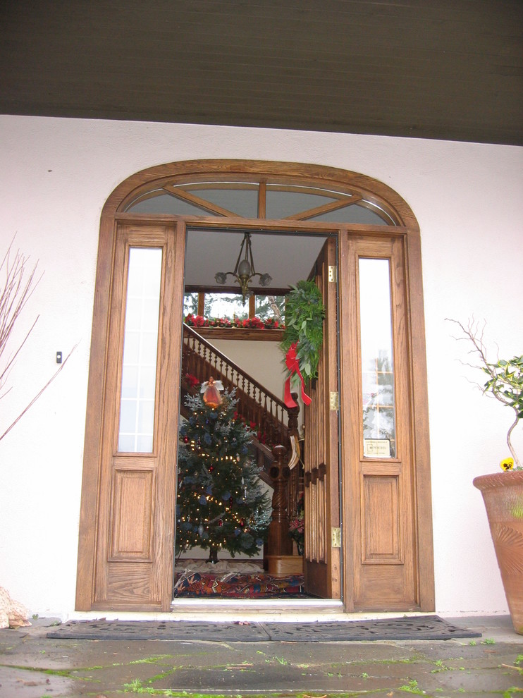 This is an example of a large victorian foyer in Vancouver with beige walls, medium hardwood flooring, a single front door, a medium wood front door and brown floors.