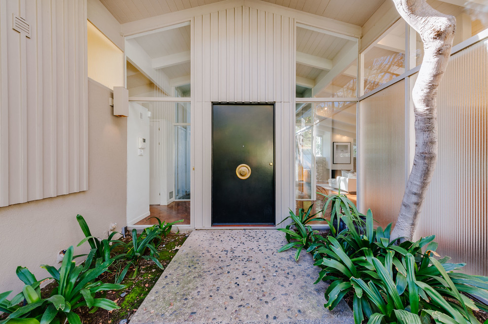 Example of a mid-sized 1950s entryway design in Los Angeles with a black front door