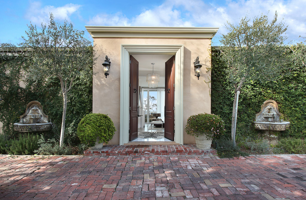Example of a large classic entryway design in Los Angeles with beige walls and a brown front door