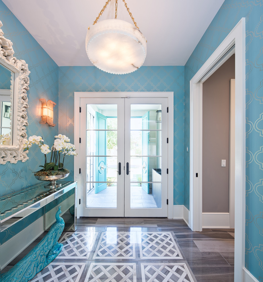 Idee per un corridoio chic con pareti blu, una porta a due ante, una porta in vetro e pavimento marrone
