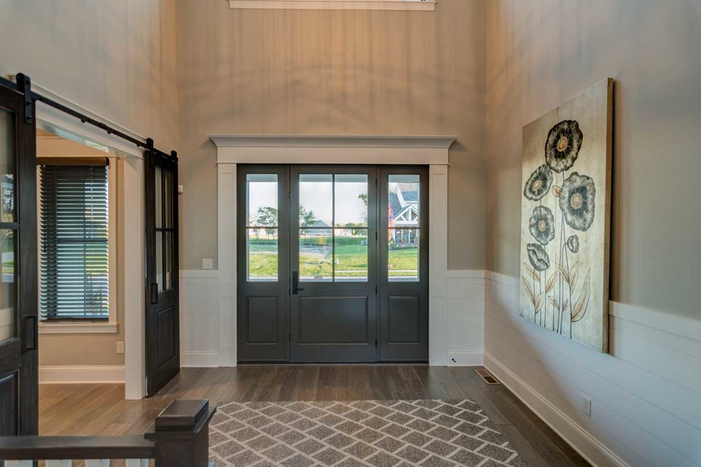 Ispirazione per una porta d'ingresso moderna con pareti beige, pavimento in legno massello medio, una porta a due ante e una porta in legno scuro