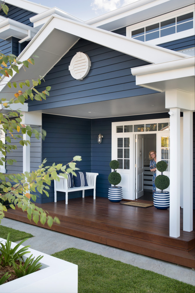 This is an example of an expansive scandi front door in Brisbane with blue walls, light hardwood flooring, a single front door, a white front door and brown floors.