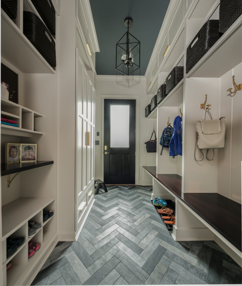 This is an example of a medium sized classic boot room in New York with grey walls, ceramic flooring, a single front door, a black front door and grey floors.