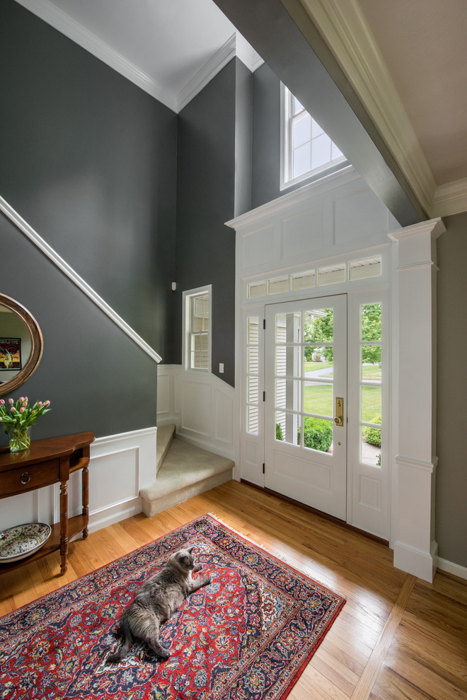 Idéer för att renovera en mellanstor vintage foajé, med grå väggar, ljust trägolv, en enkeldörr och en svart dörr