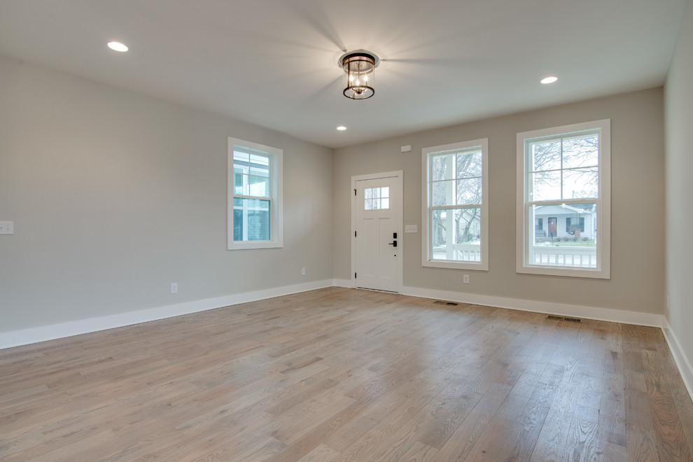 Photo of a large traditional entrance in Nashville with beige walls, light hardwood flooring and a white front door.