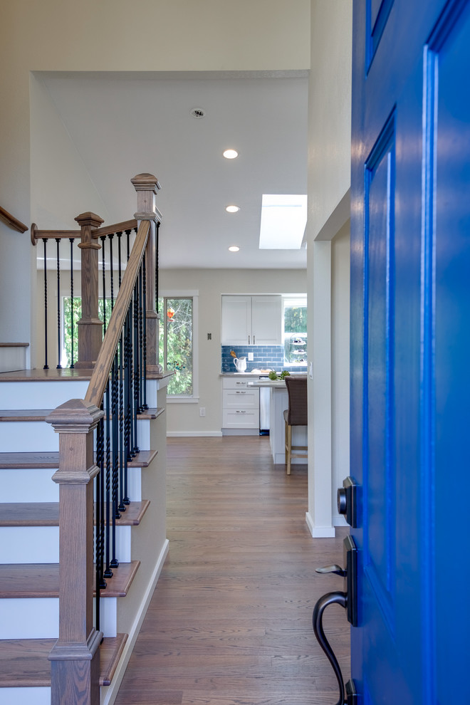 Aménagement d'un hall d'entrée classique de taille moyenne avec un mur blanc, une porte simple, une porte bleue, un sol en bois brun et un sol marron.