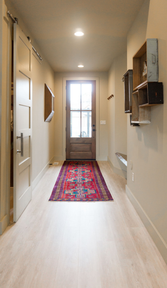Kleiner Eklektischer Eingang mit Korridor, gelber Wandfarbe, Vinylboden, Einzeltür, hellbrauner Holzhaustür und beigem Boden in Boise