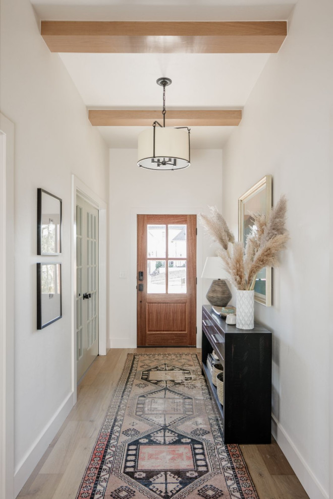 Foto di una porta d'ingresso chic di medie dimensioni con pareti bianche, parquet chiaro, una porta singola, una porta in legno bruno, pavimento beige e travi a vista
