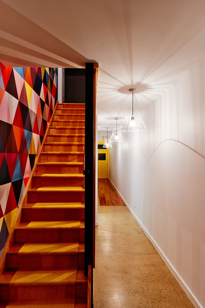 Immagine di un corridoio minimalista di medie dimensioni con pareti bianche, pavimento in legno massello medio, una porta singola e una porta gialla