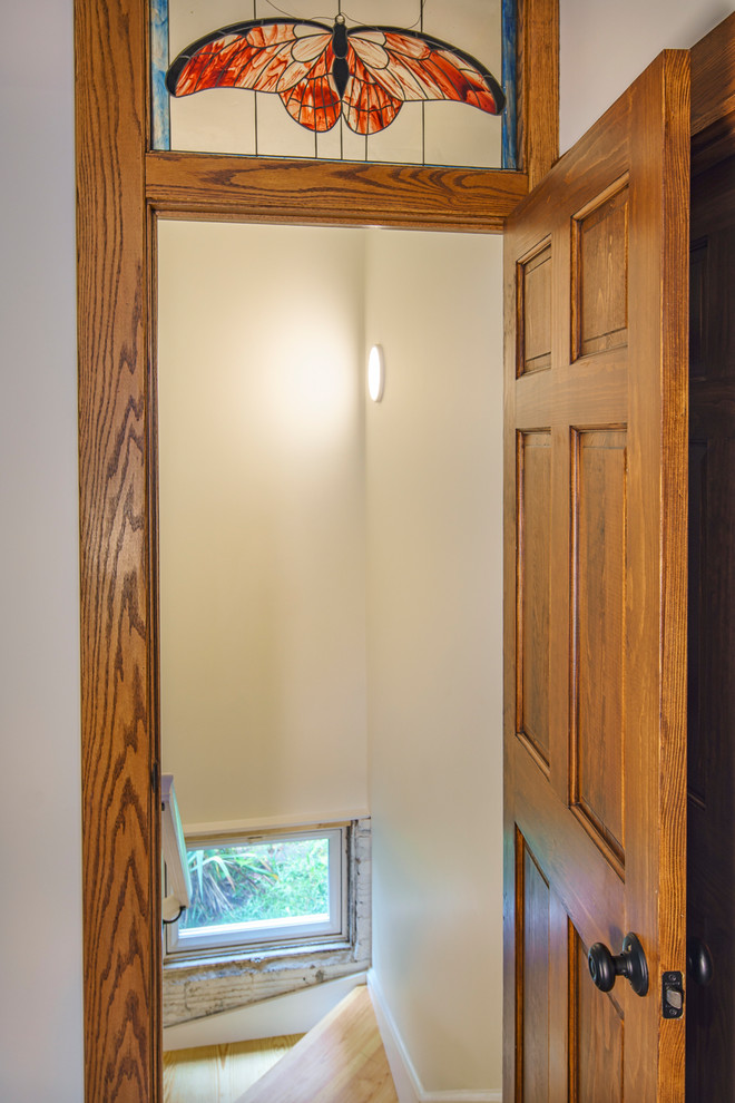 ワシントンD.C.にある中くらいなトラディショナルスタイルのおしゃれな玄関 (白い壁、淡色無垢フローリング、濃色木目調のドア、茶色い床) の写真