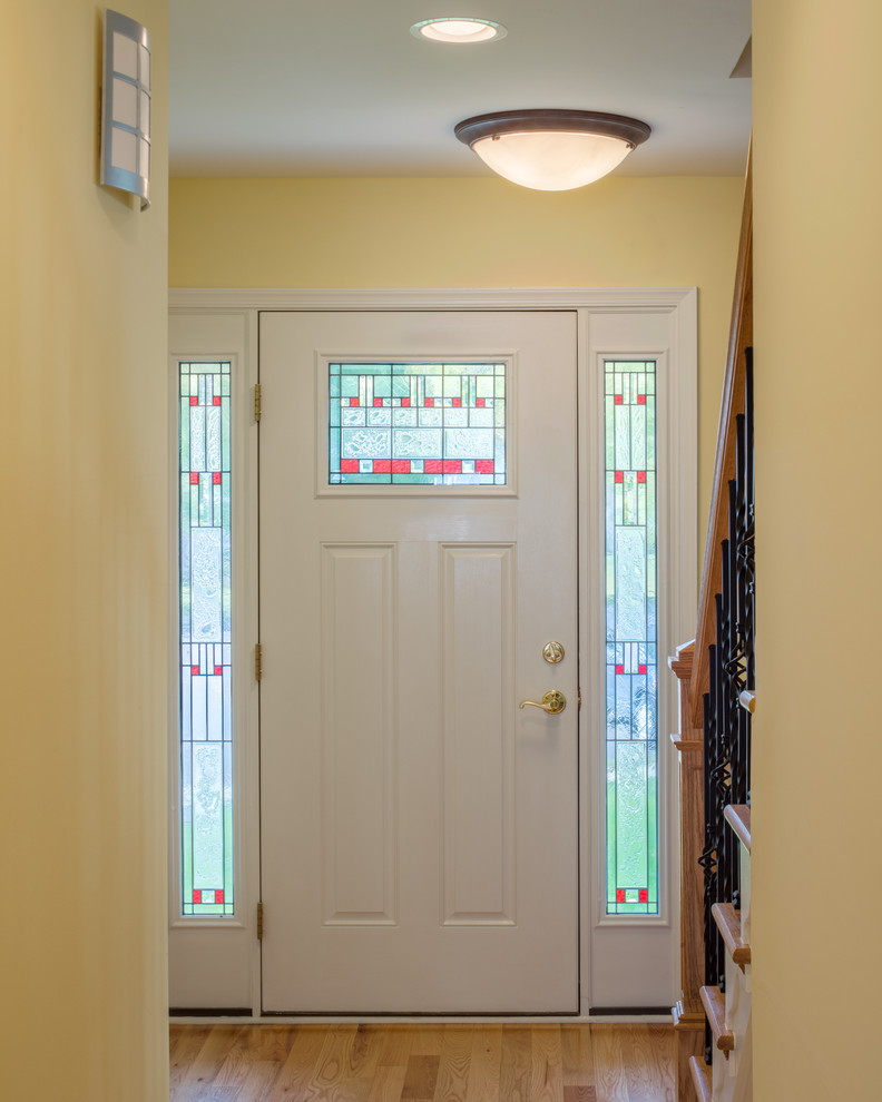 Bild på en liten vintage ingång och ytterdörr, med beige väggar, ljust trägolv, en enkeldörr och en vit dörr
