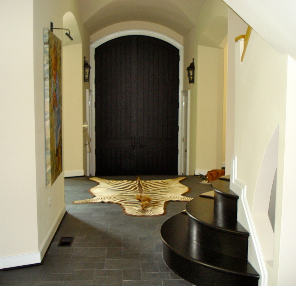 Идея дизайна: огромная узкая прихожая в стиле неоклассика (современная классика) с белыми стенами, полом из известняка, двустворчатой входной дверью, входной дверью из темного дерева и синим полом