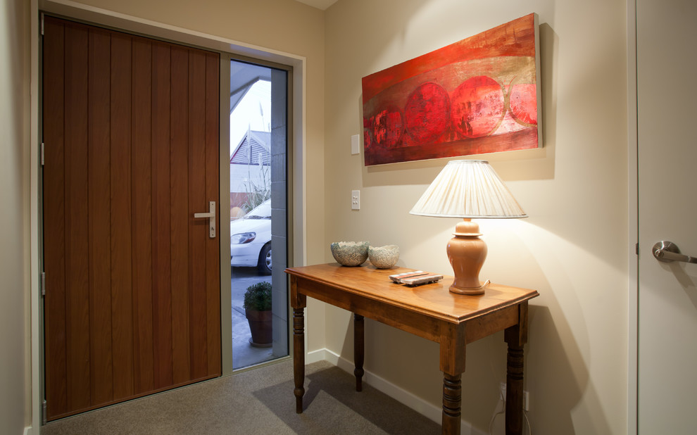 Свежая идея для дизайна: входная дверь среднего размера в современном стиле с бежевыми стенами, ковровым покрытием, одностворчатой входной дверью и входной дверью из дерева среднего тона - отличное фото интерьера