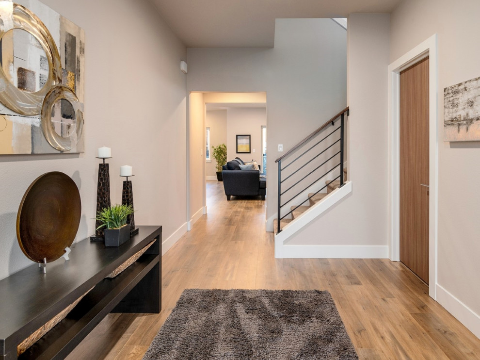 Example of a large transitional medium tone wood floor and brown floor entry hall design in Portland with gray walls