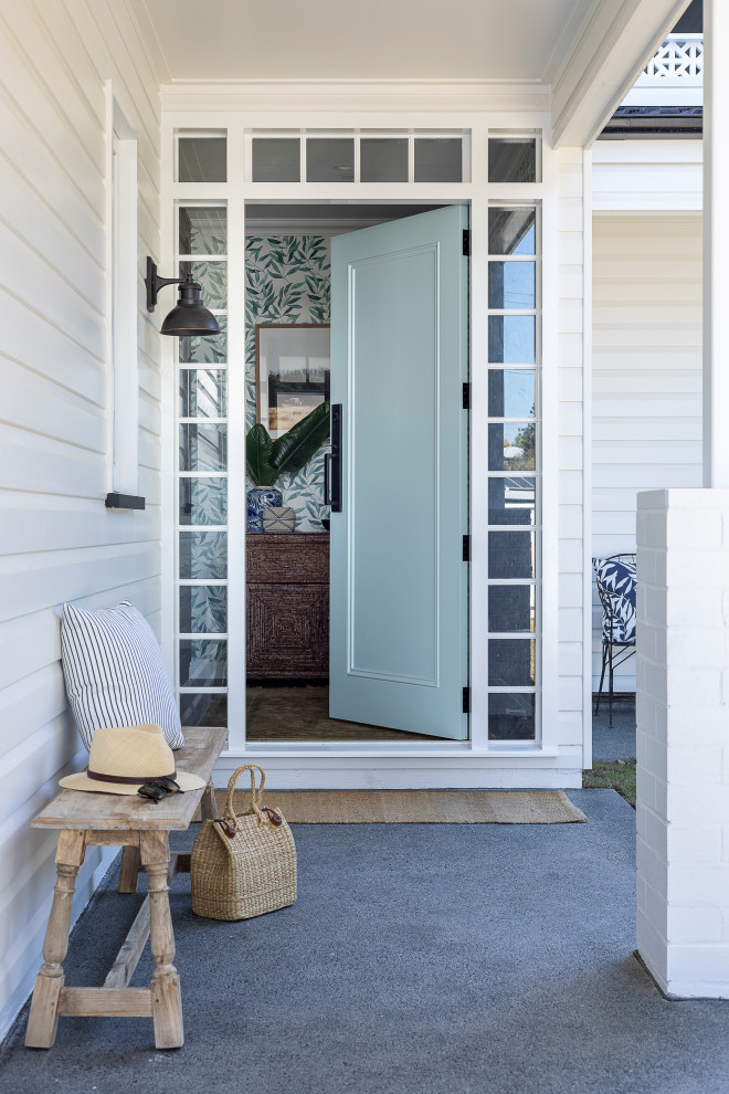 На фото: узкая прихожая среднего размера с белыми стенами, одностворчатой входной дверью и зеленой входной дверью с