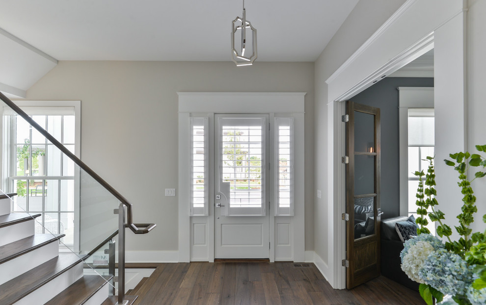 Foto di un corridoio chic di medie dimensioni con pareti bianche, parquet scuro, una porta singola e una porta bianca