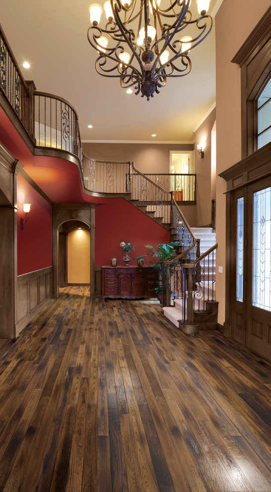 Imagen de hall clásico grande con paredes rojas, suelo de madera oscura, puerta simple, puerta de madera oscura y suelo marrón