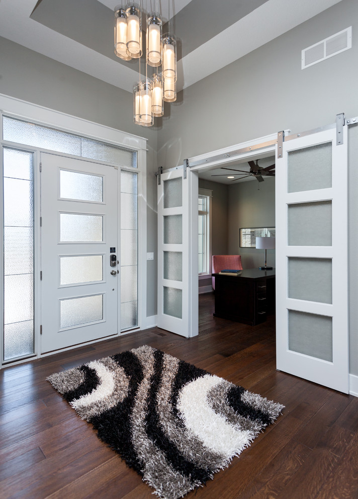Moderner Eingang mit grauer Wandfarbe, dunklem Holzboden, Einzeltür und weißer Haustür in Sonstige