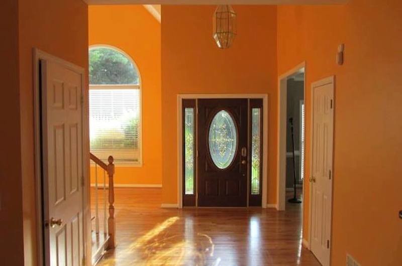 Источник вдохновения для домашнего уюта: узкая прихожая в стиле фьюжн с оранжевыми стенами, светлым паркетным полом, одностворчатой входной дверью и входной дверью из темного дерева