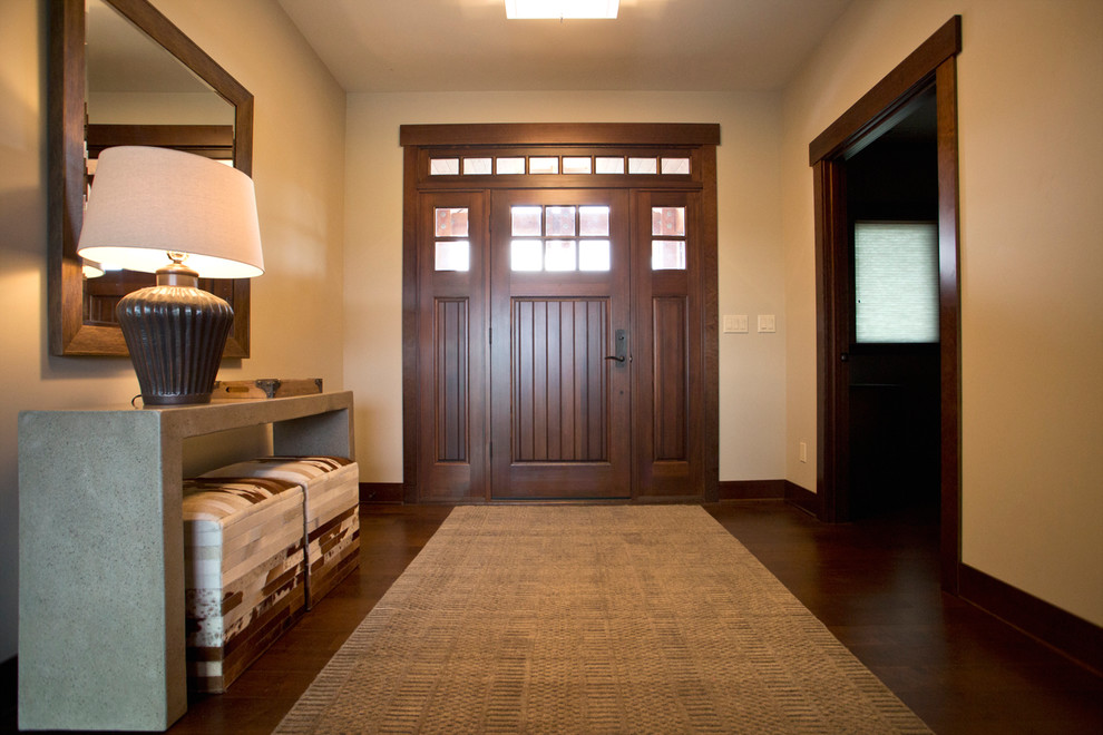 Immagine di una porta d'ingresso tradizionale di medie dimensioni con pareti beige, pavimento in legno massello medio, una porta singola e una porta in legno bruno