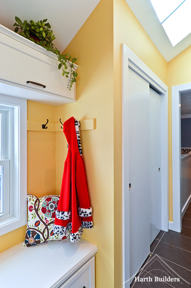 Immagine di un piccolo ingresso con anticamera chic con pareti gialle, pavimento con piastrelle in ceramica, una porta singola e una porta bianca