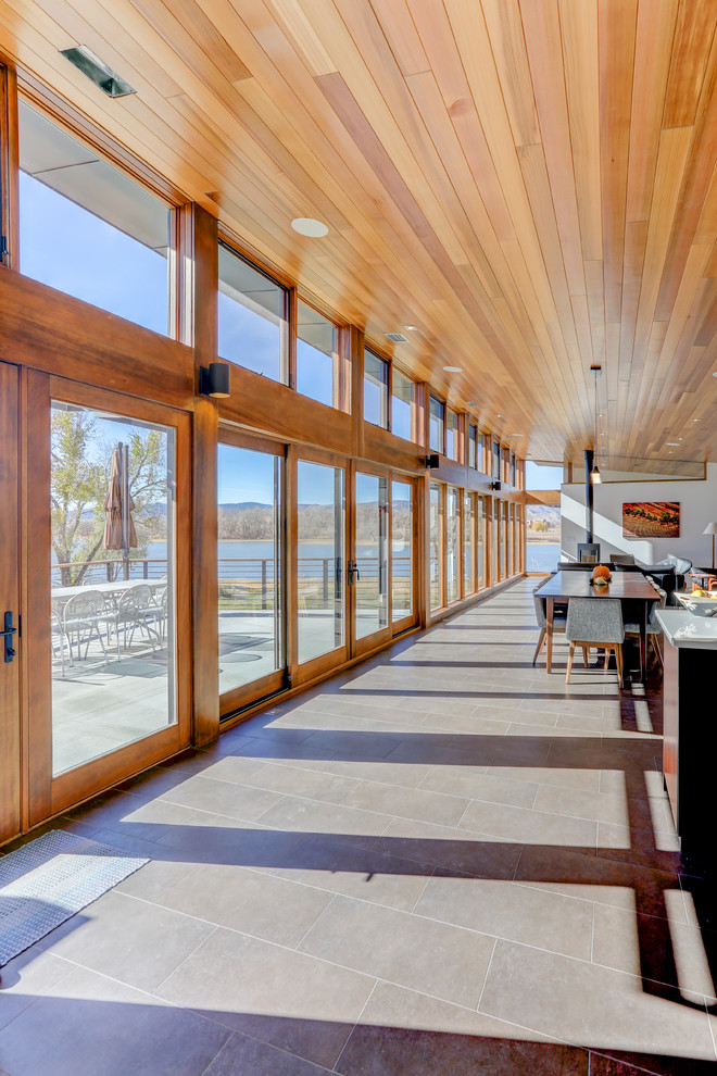 Mittelgroßes Modernes Foyer mit Porzellan-Bodenfliesen, Einzeltür, hellbrauner Holzhaustür und brauner Wandfarbe in Denver