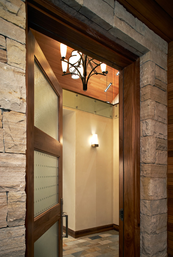 Example of a mid-sized trendy travertine floor entryway design in Denver with beige walls and a glass front door