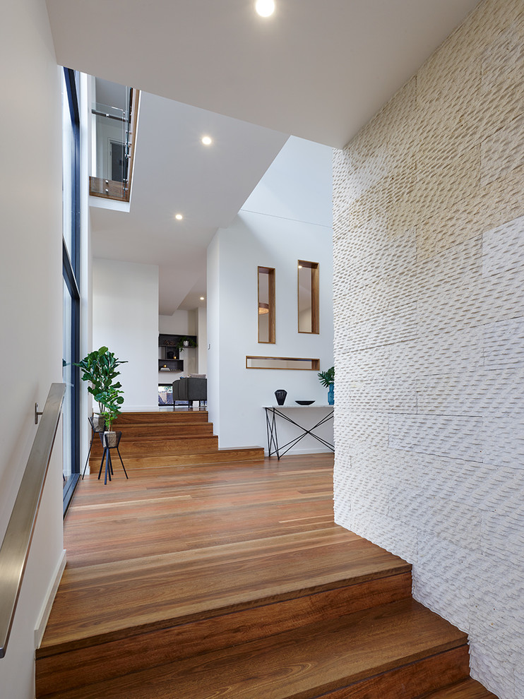 Mid-sized trendy medium tone wood floor entryway photo in Melbourne with beige walls and a glass front door