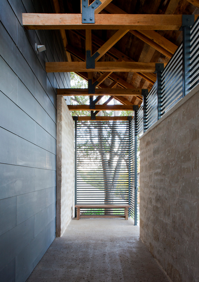 На фото: большое фойе в стиле неоклассика (современная классика) с бетонным полом, поворотной входной дверью и металлической входной дверью
