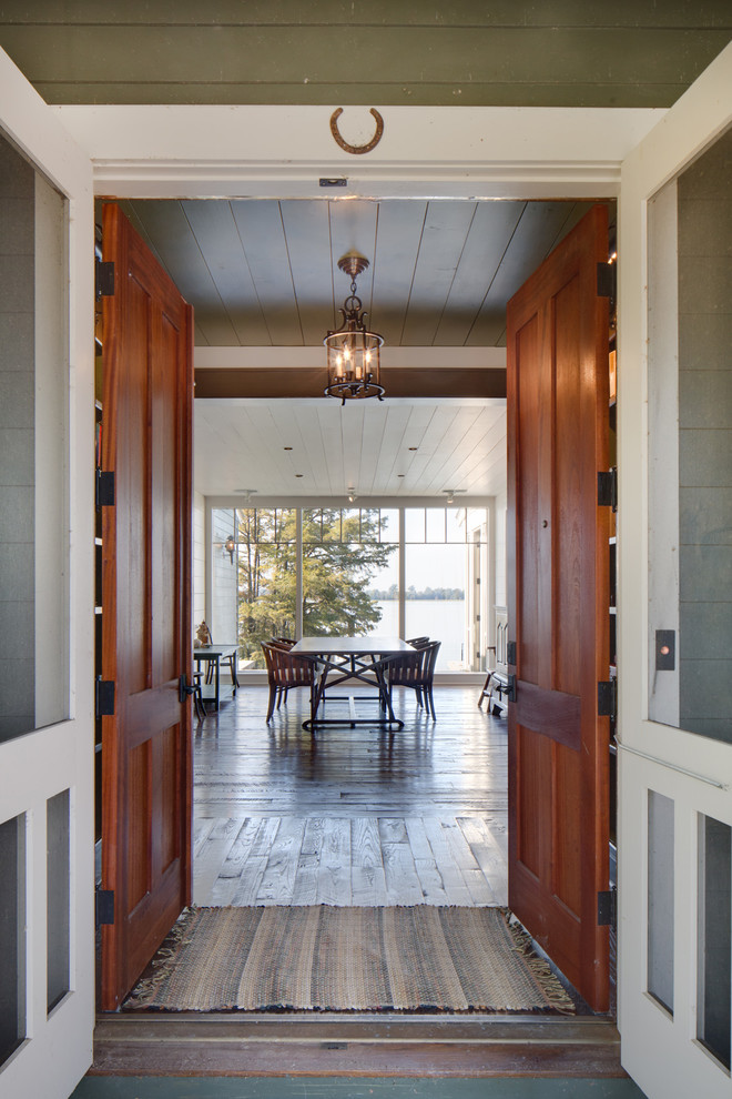 Cette image montre un hall d'entrée rustique de taille moyenne avec une porte double, un sol en bois brun, une porte en bois brun et un sol marron.