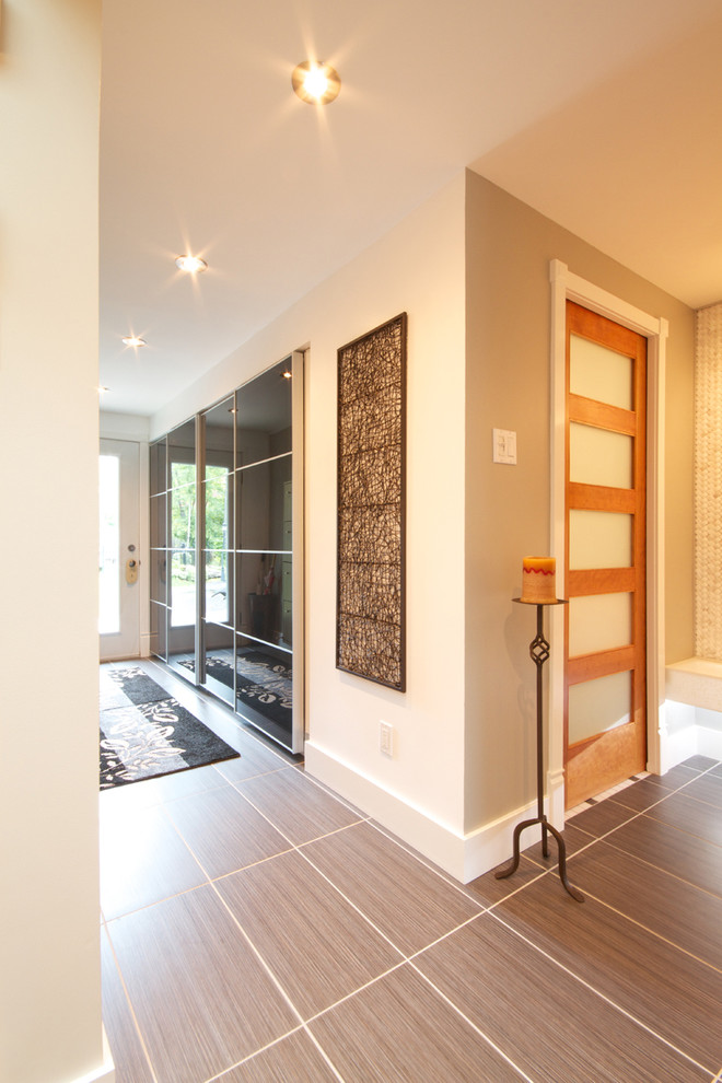 Источник вдохновения для домашнего уюта: узкая прихожая среднего размера в современном стиле с одностворчатой входной дверью, серыми стенами, полом из керамогранита, белой входной дверью и серым полом