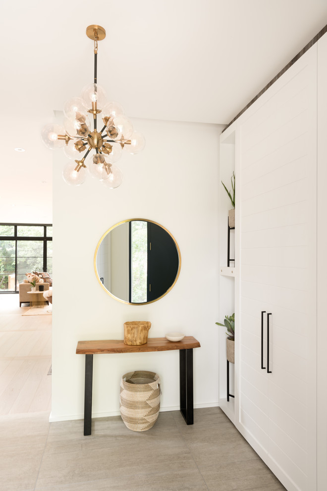 Ejemplo de distribuidor nórdico grande con paredes blancas, suelo de baldosas de porcelana, puerta simple, puerta negra y suelo gris
